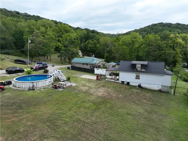 a view of a house with backyard sitting area and swimming pool