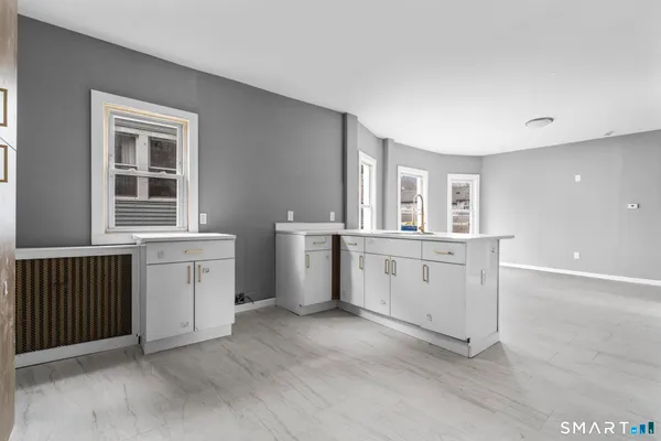 a kitchen with white cabinets and sink