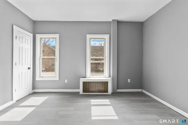 a view of an empty room with a window and a fireplace