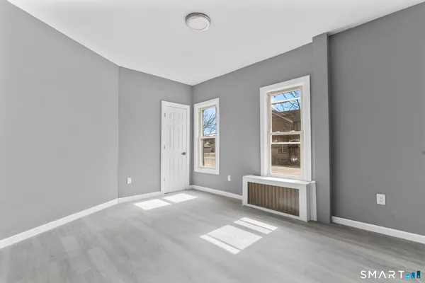 an empty room with windows and cabinet