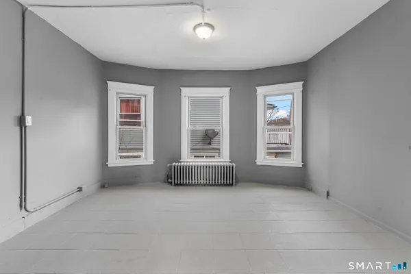 an empty room with fireplace and windows