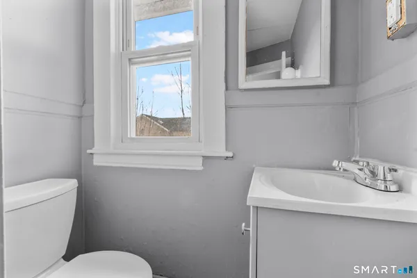 a bathroom with a sink mirror and toilet