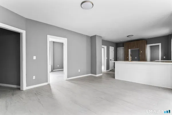a view of an empty room with window and cabinet