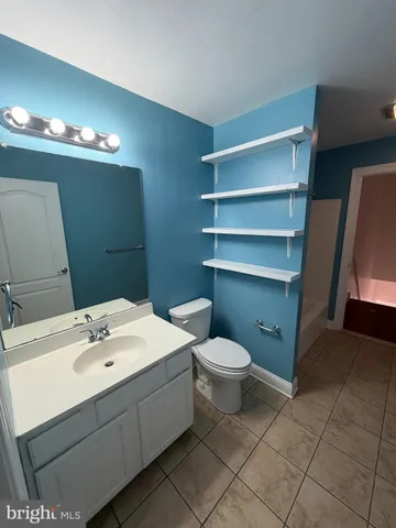 a bathroom with a sink vanity and a toilet