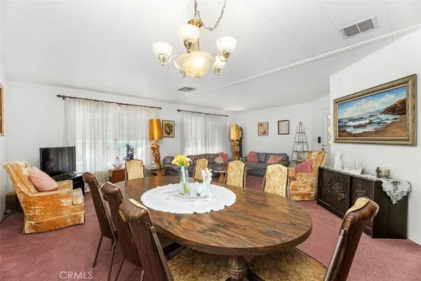a view of a dining room with furniture and chandelier