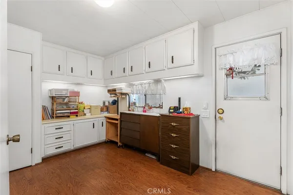a room with white cabinets and wooden floors