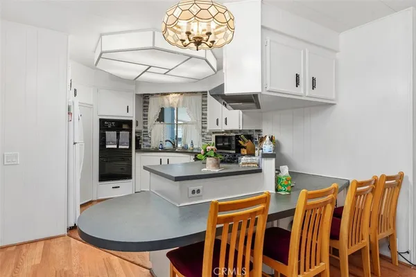 a dining room with furniture a kitchen and chandelier