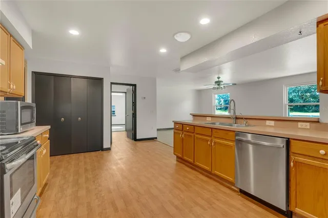 a large kitchen with stainless steel appliances granite countertop a sink and a stove top oven