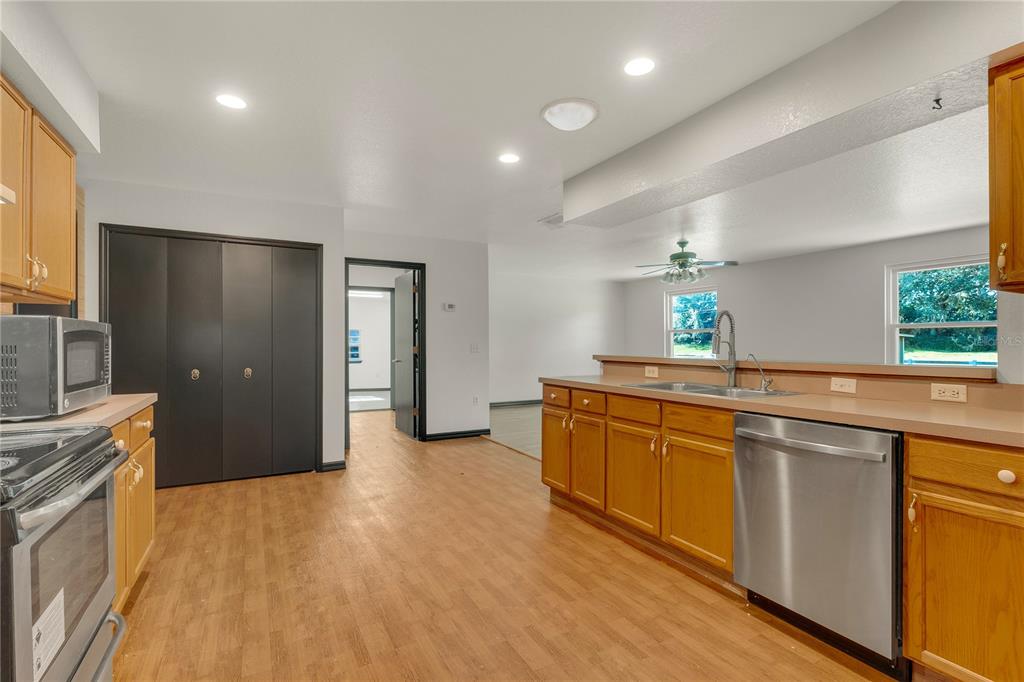 4831 Rummell Road St. Cloud, FL 34771 - Photo 13 of 37 a large kitchen with stainless steel appliances granite countertop a sink and a stove top oven
