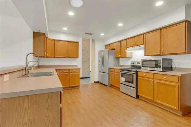 a kitchen with stainless steel appliances granite countertop a sink stove and refrigerator