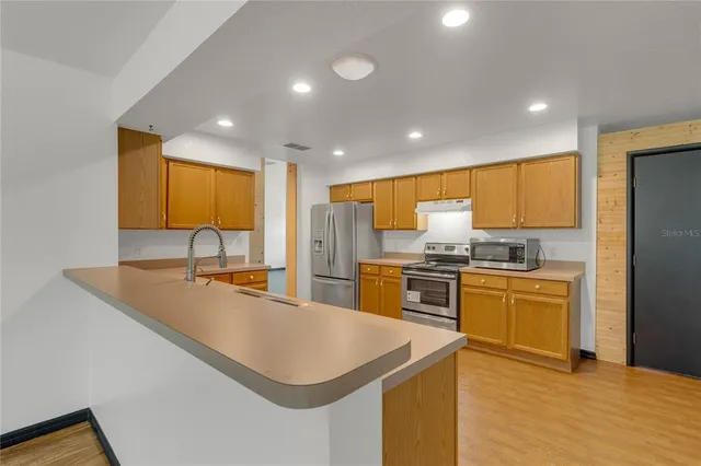 a kitchen with stainless steel appliances granite countertop a sink stove and refrigerator