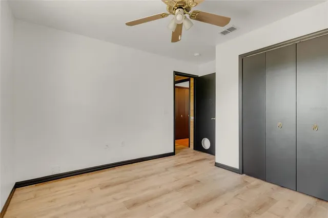 a view of an empty room and chandelier fan