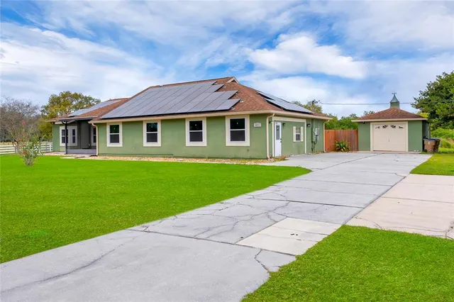 a front view of a house with a garden and yard