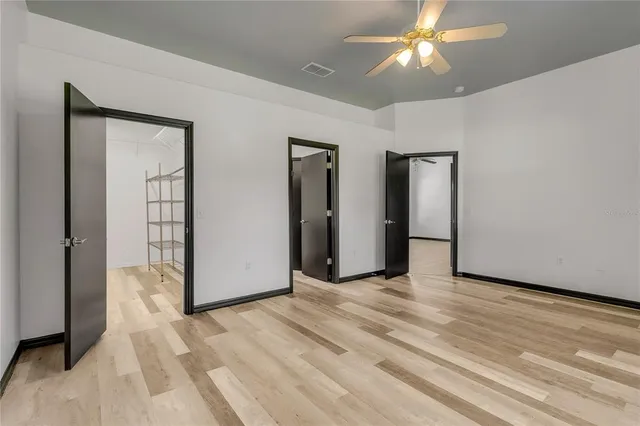 an empty room with fan and entrance