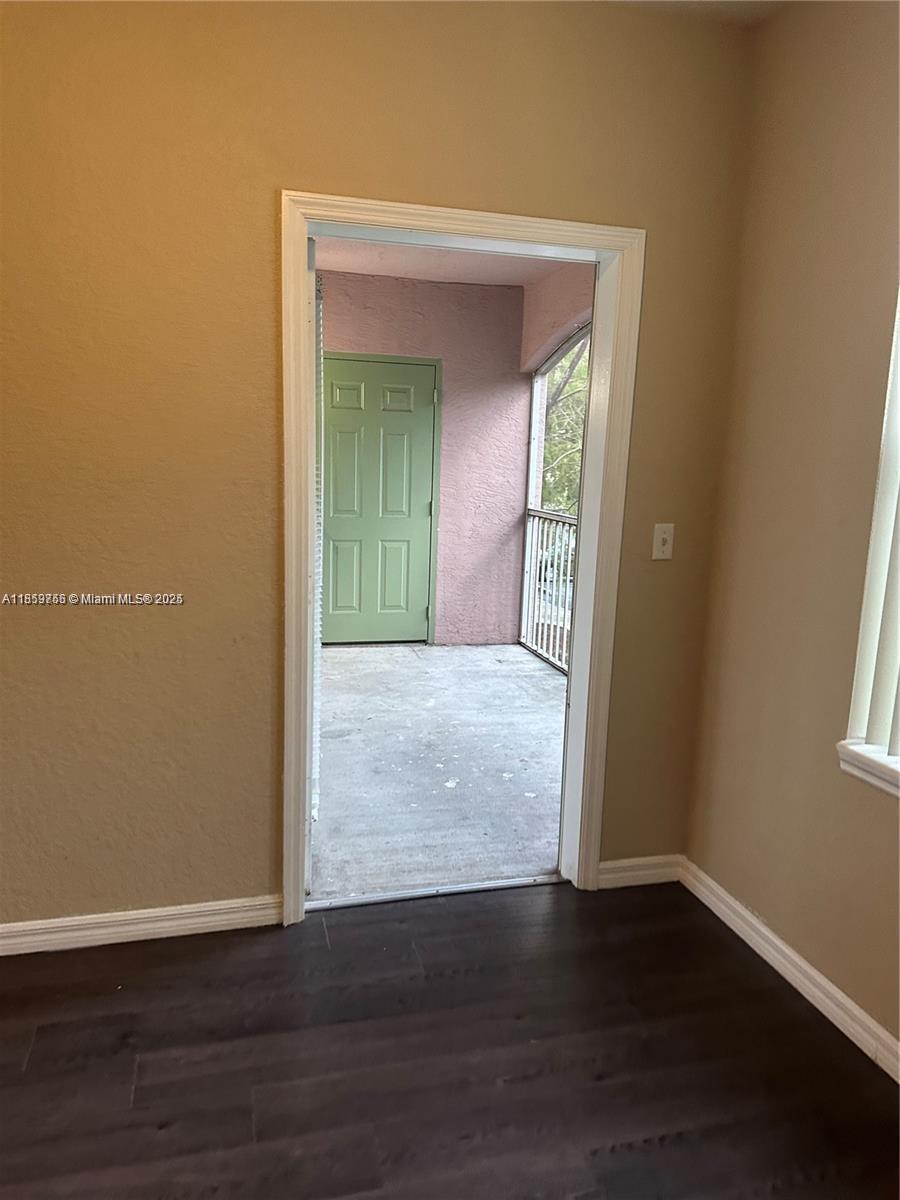 6790 West Sample Road, Unit 6790 Coral Springs, FL 33067 - Photo 13 of 26 a view of an empty room with wooden floor and a window