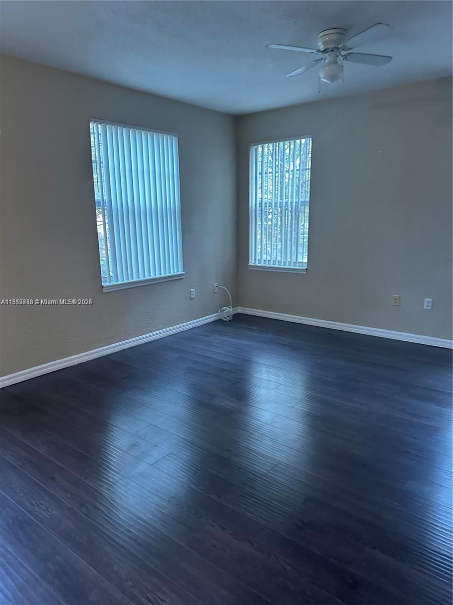 6790 West Sample Road, Unit 6790 Coral Springs, FL 33067 - Photo 24 of 26 an empty room with wooden floor and windows