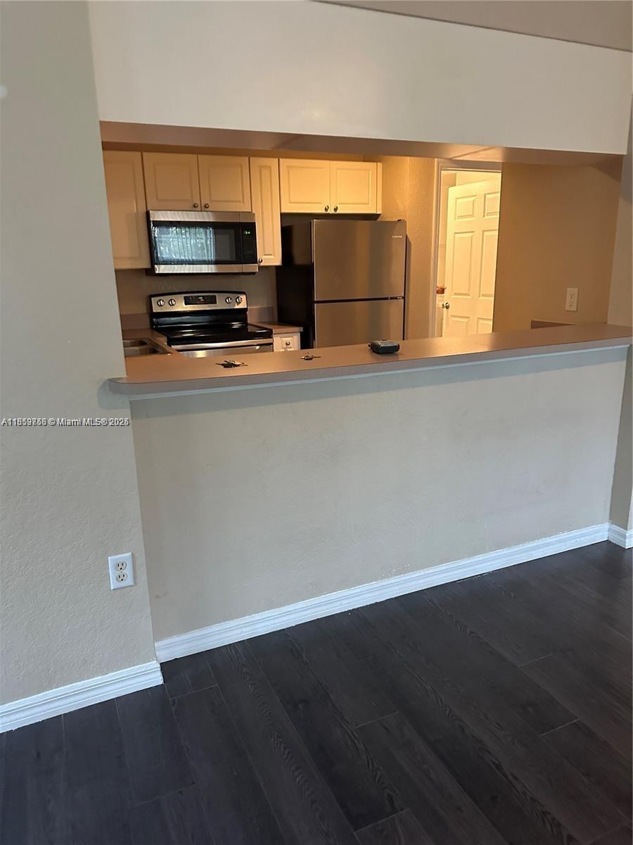 6790 West Sample Road, Unit 6790 Coral Springs, FL 33067 - Photo 8 of 26 a kitchen with a refrigerator and a stove top oven