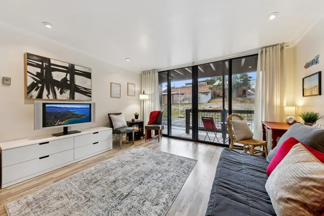 a living room with furniture large window and flat screen tv