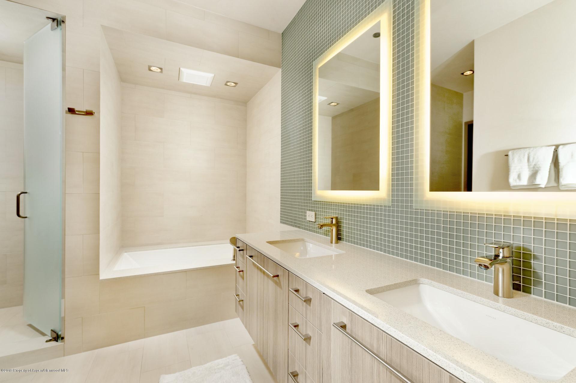 217 South 3rd Street Aspen, CO 81611 - Photo 17 of 32 a bathroom with a double vanity sink a mirror and a shower
