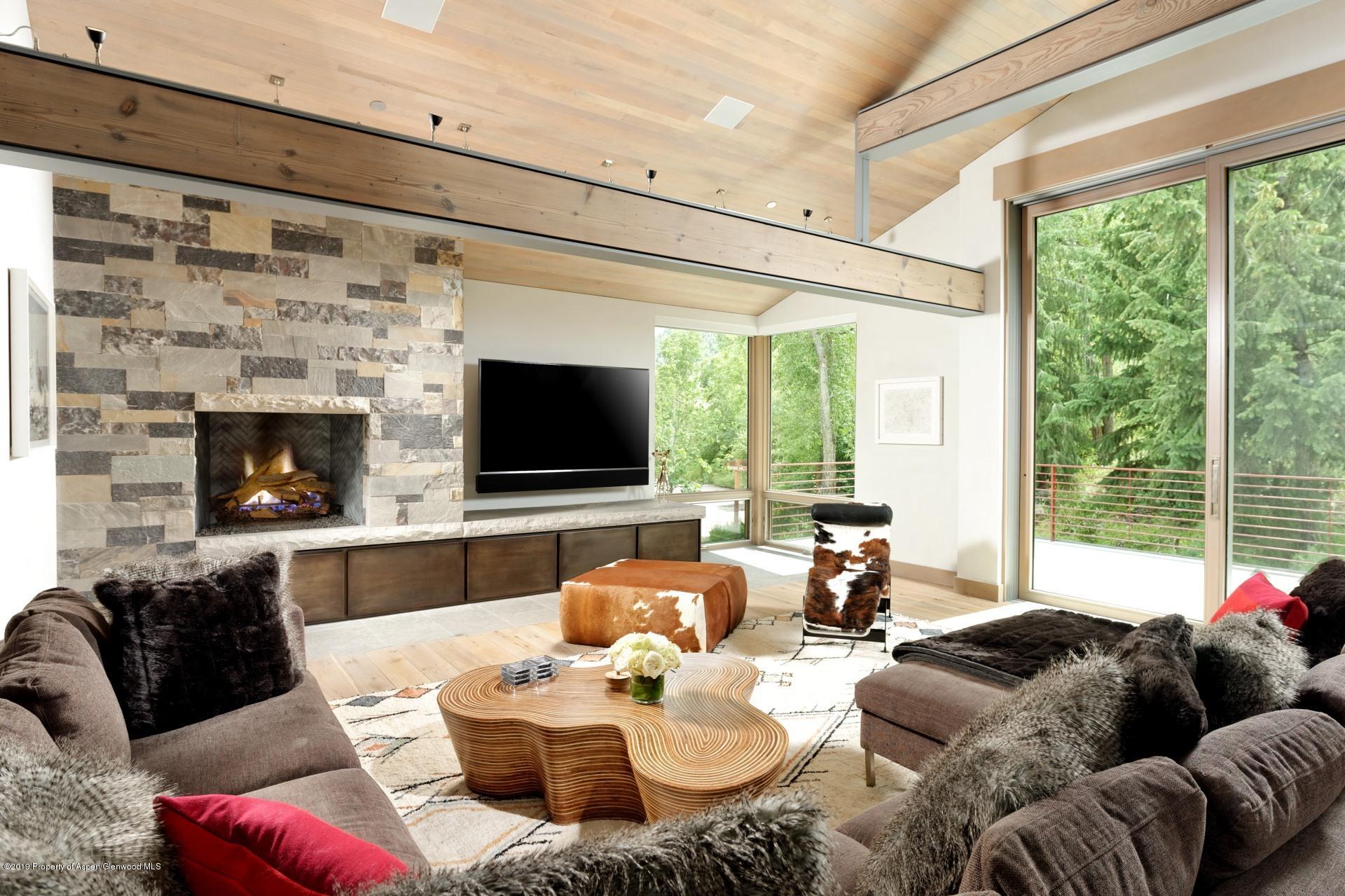 217 South 3rd Street Aspen, CO 81611 - Photo 4 of 32 a living room with furniture a large window and a flat screen tv