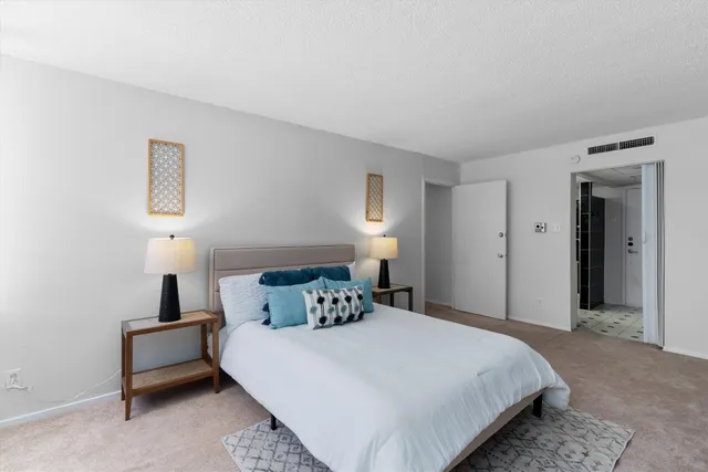 a bedroom with a bed and a potted plant