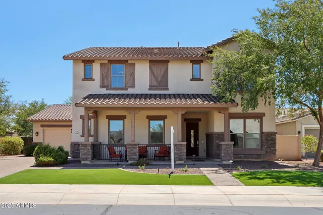 a view of a house with a yard and large tree and plants