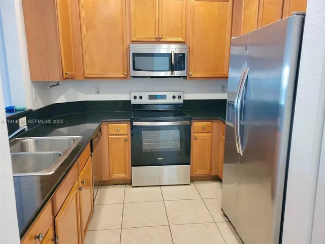 a kitchen with stainless steel appliances granite countertop a stove a microwave and a sink