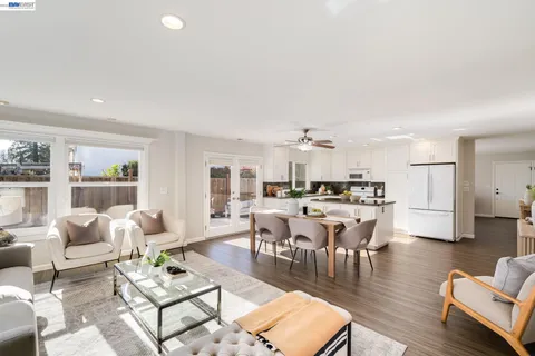 a living room with lots of furniture and view of kitchen
