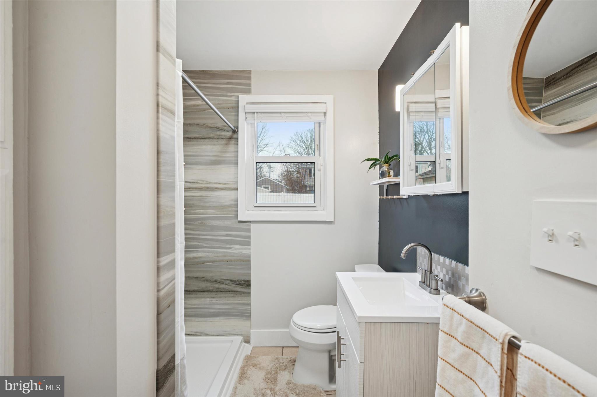 508 5th Avenue Barrington, NJ 08007 - Photo 14 of 28 a bathroom with a toilet sink and mirror