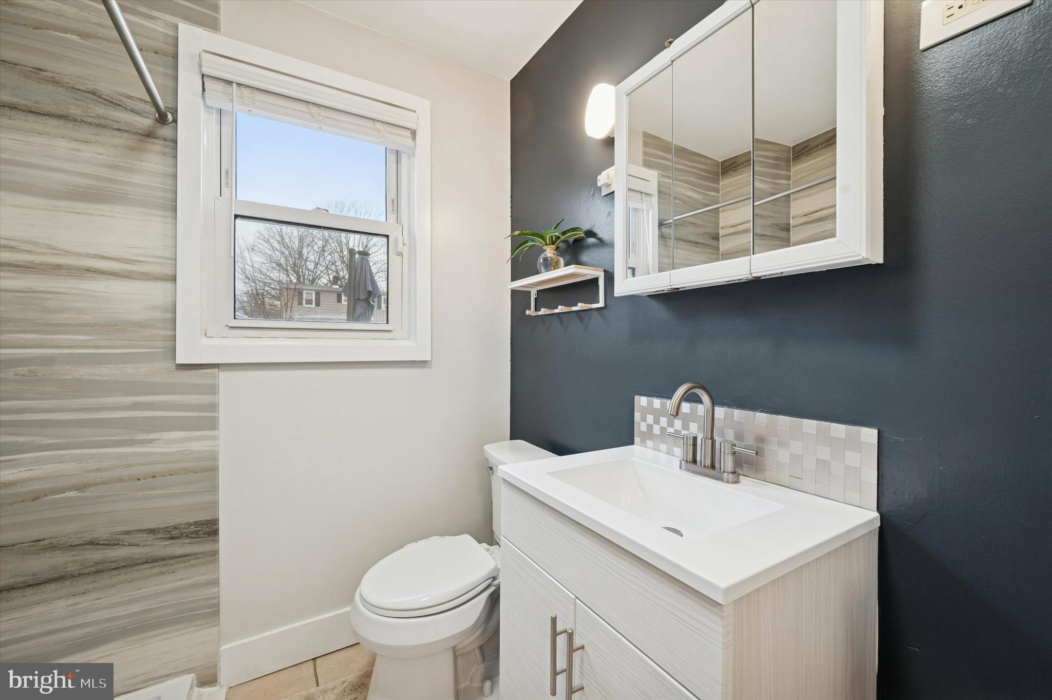 508 5th Avenue Barrington, NJ 08007 - Photo 15 of 28 a bathroom with a toilet a sink and mirror