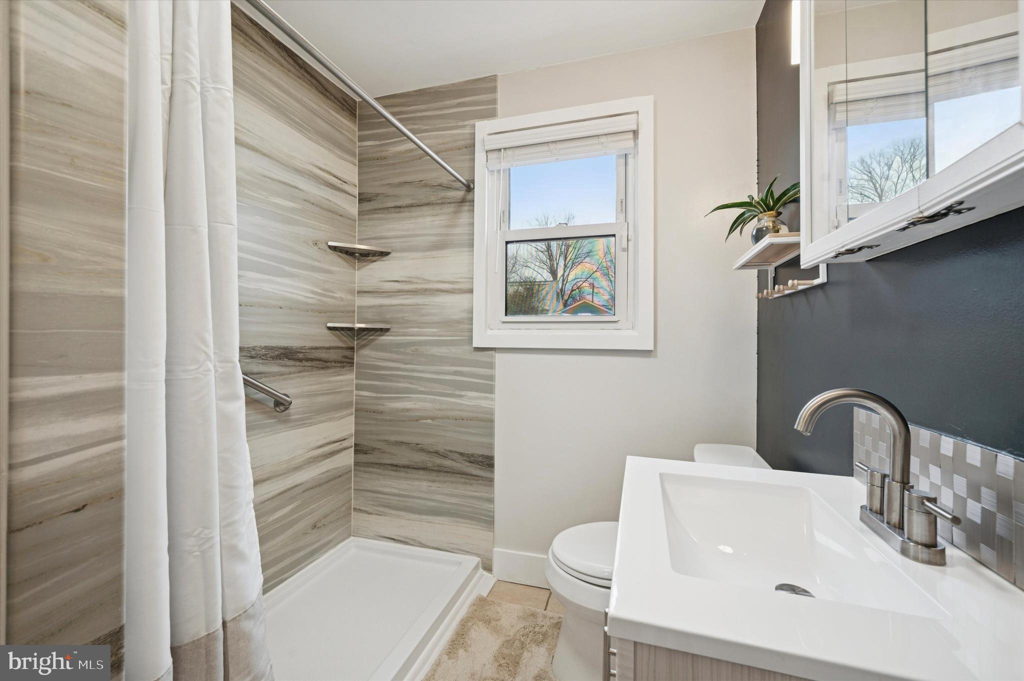 508 5th Avenue Barrington, NJ 08007 - Photo 16 of 28 a bathroom with a toilet a sink and shower