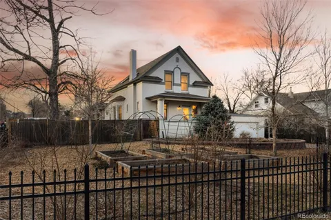 a view of a brick house with large windows and a small yard