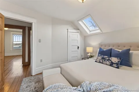 a bedroom with a large bed and wooden floor