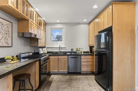 a kitchen with granite countertop stainless steel appliances and wooden cabinets