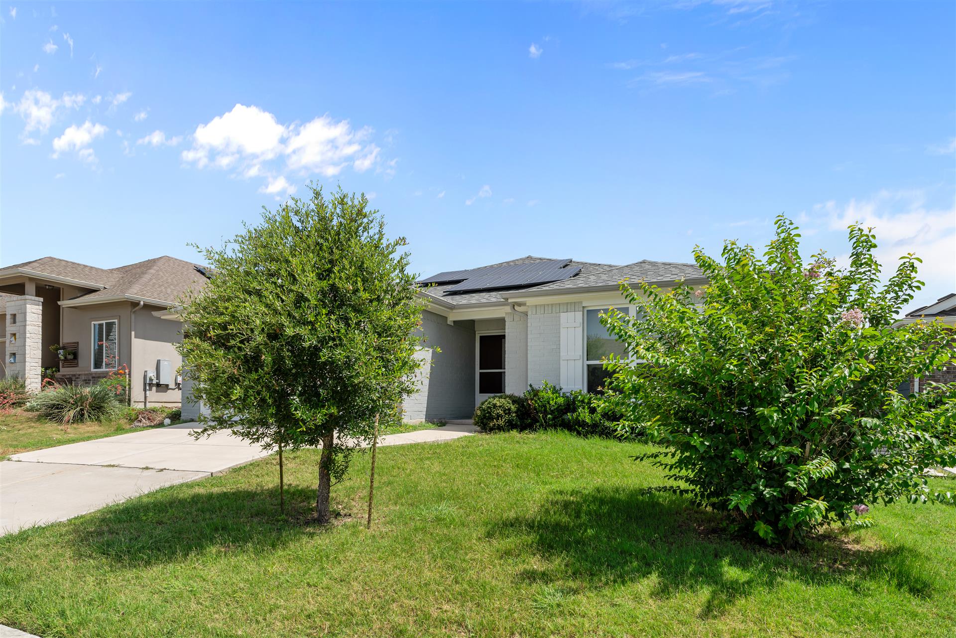 16512 Enamorado Road Manor, TX 78653 - Photo 14 of 31 A neatly maintained lawn and mature landscaping enhance this welcoming home's facade.