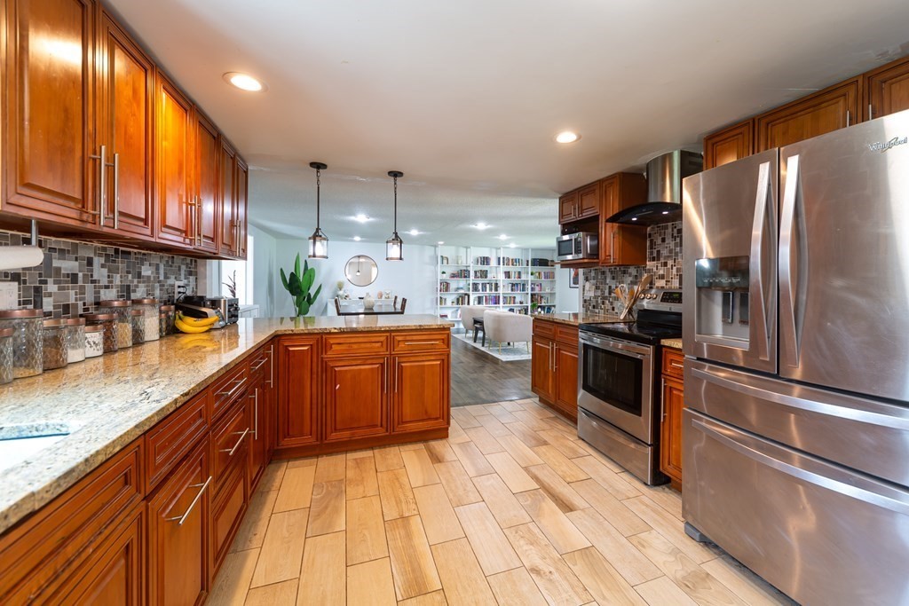 17 Lindsay Road Billerica, MA 01821 - Photo 4 of 42 a kitchen with stainless steel appliances granite countertop a refrigerator a sink dishwasher a stove with wooden cabinets and floor