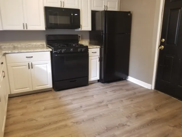 a kitchen with a refrigerator and a stove top oven