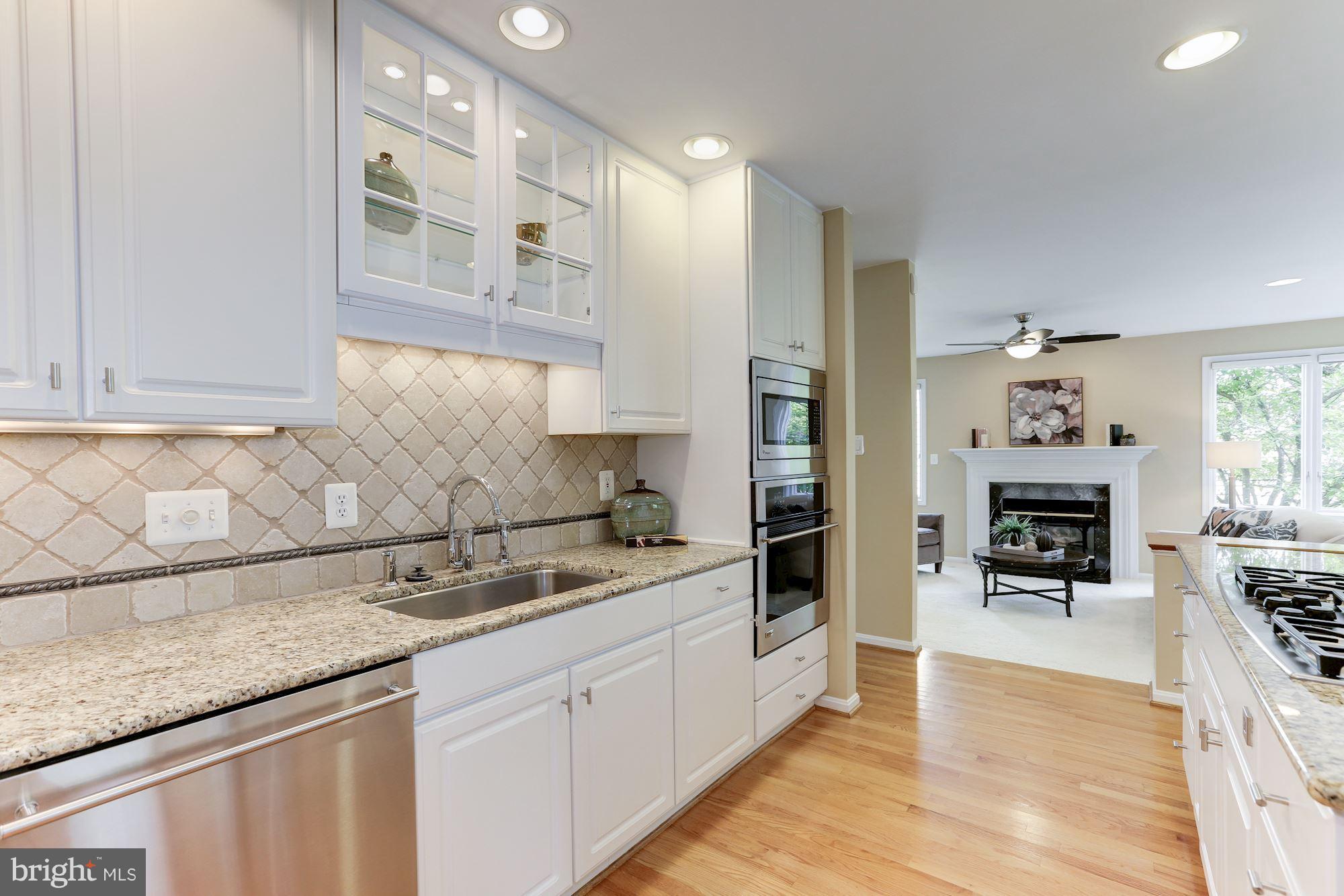 1311 Pavilion Club Way Reston, VA 20194 - Photo 11 of 28 a kitchen with granite countertop a sink a stove cabinets and counter space