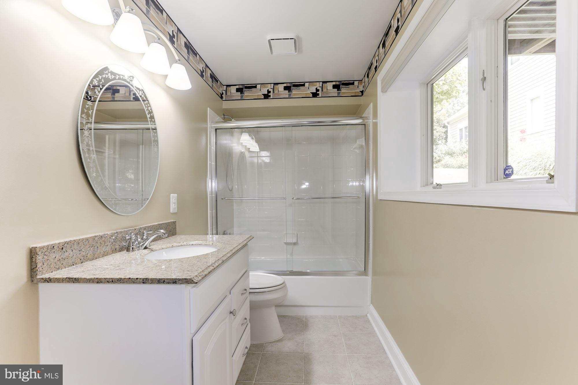 1311 Pavilion Club Way Reston, VA 20194 - Photo 24 of 28 a bathroom with a granite countertop sink a mirror and a shower