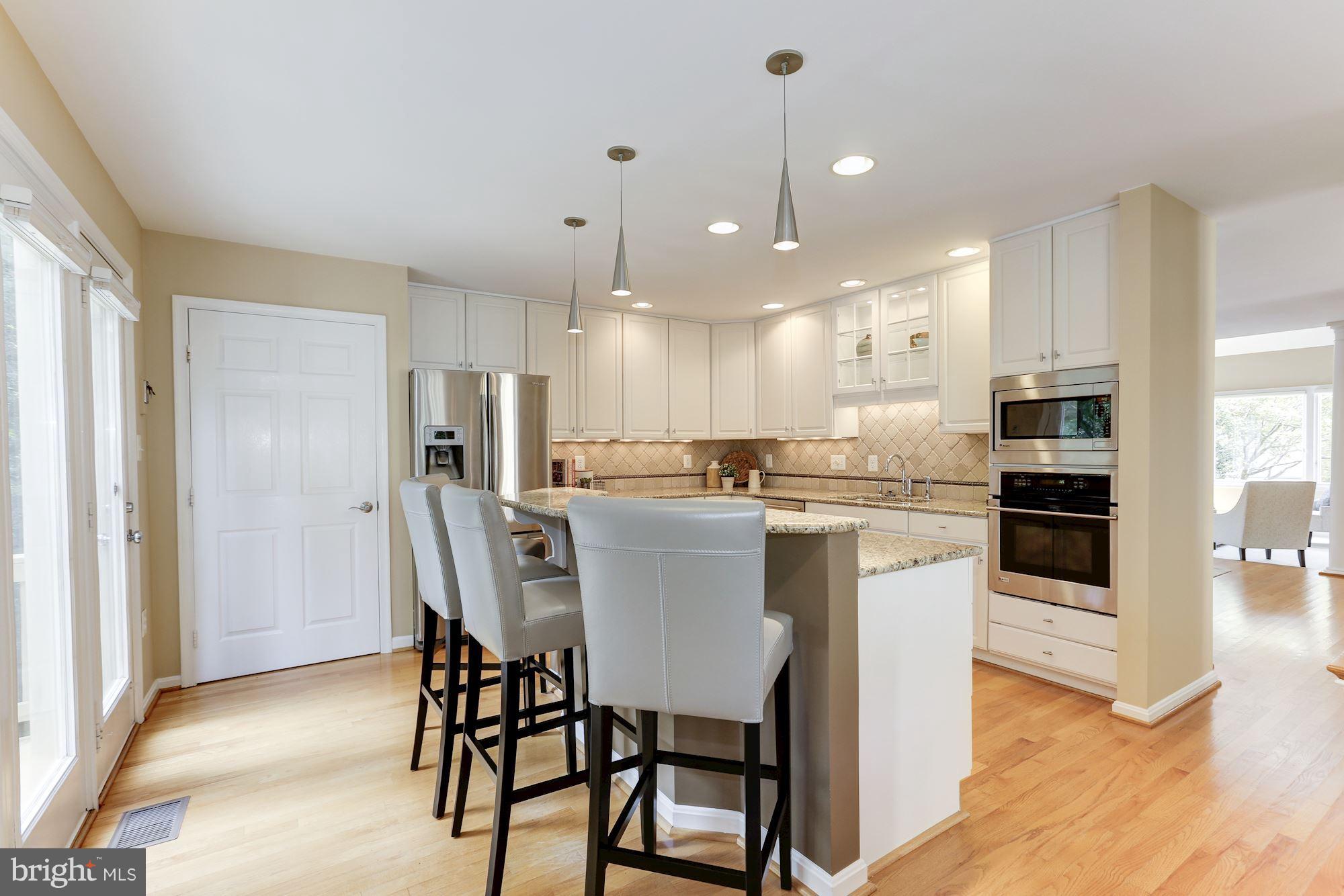 1311 Pavilion Club Way Reston, VA 20194 - Photo 9 of 28 a kitchen with kitchen island wooden cabinets and refrigerator