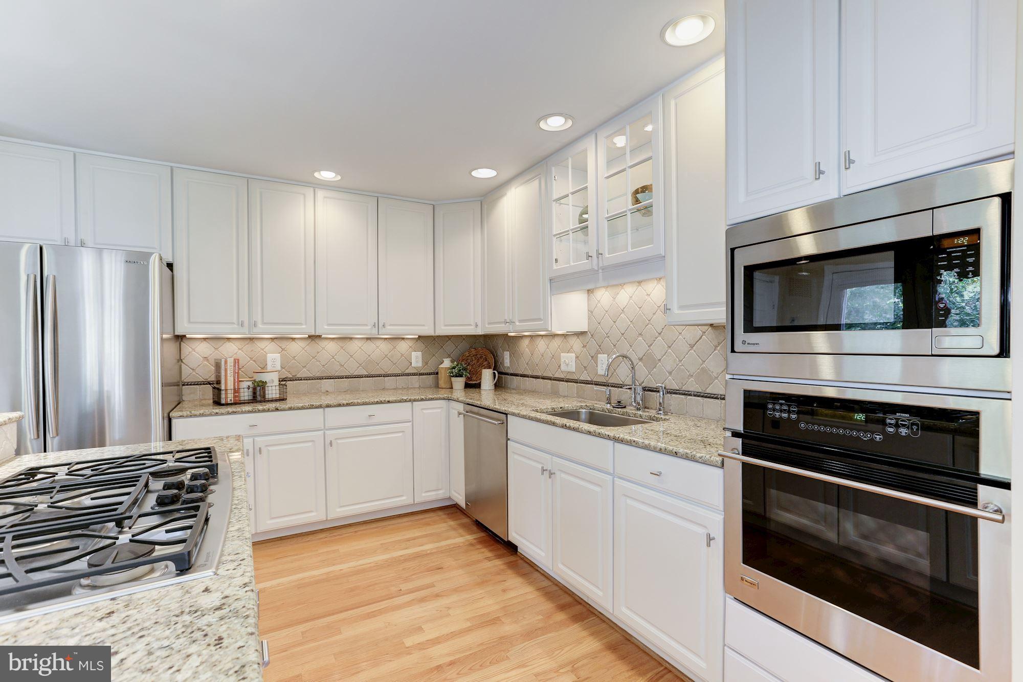 1311 Pavilion Club Way Reston, VA 20194 - Photo 10 of 28 a kitchen with stainless steel appliances granite countertop a stove and a microwave