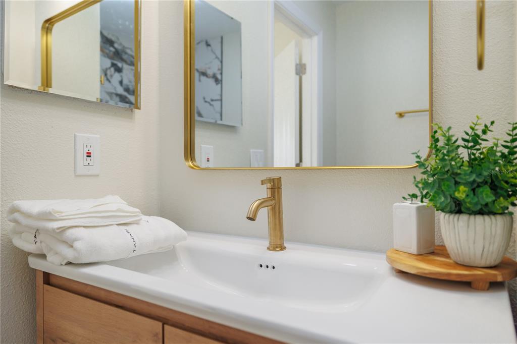 6922 Woodlake Drive, Unit 103 Orlando, FL 32810 - Photo 11 of 16 a bathroom with a sink and a mirror