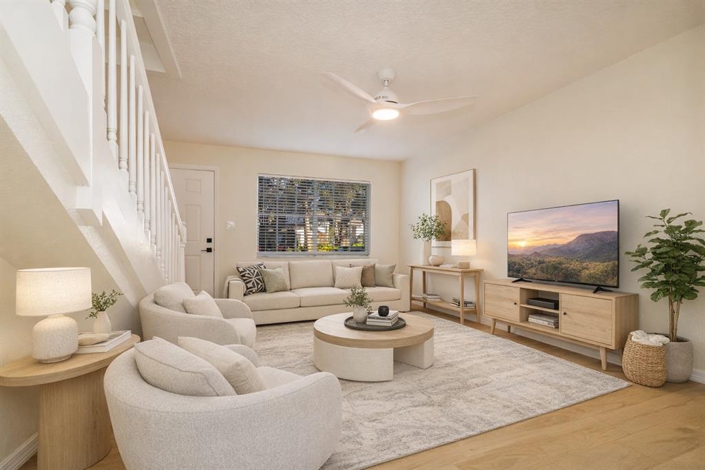 6922 Woodlake Drive, Unit 103 Orlando, FL 32810 - Photo 3 of 16 a living room with furniture a flat screen tv and a large window
