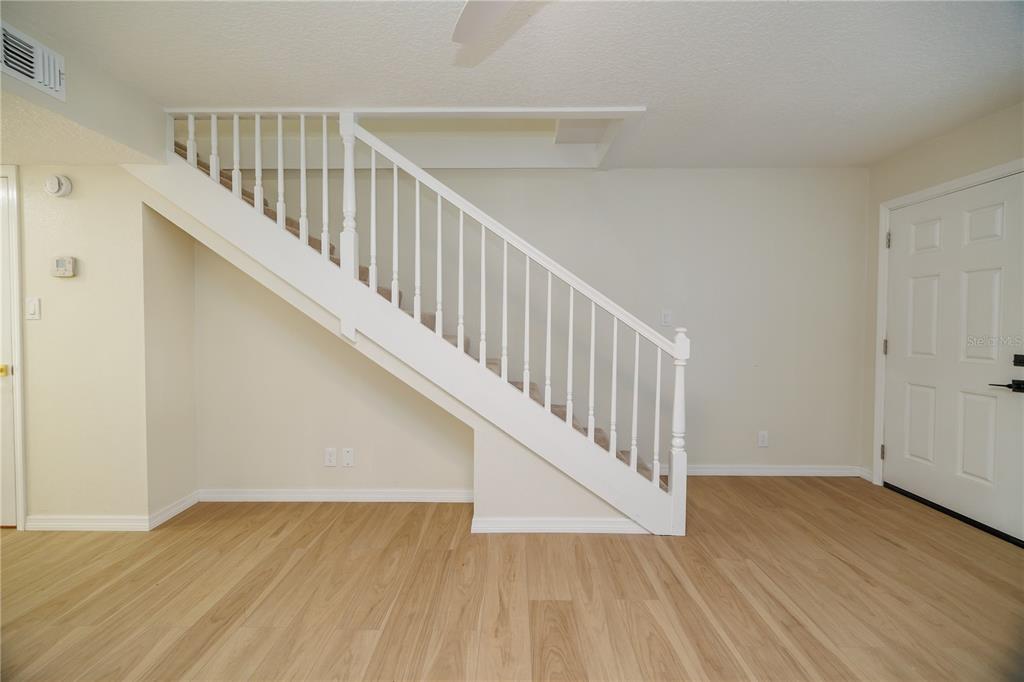 6922 Woodlake Drive, Unit 103 Orlando, FL 32810 - Photo 7 of 16 a view of staircase with wooden floor