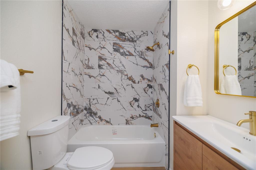 6922 Woodlake Drive, Unit 103 Orlando, FL 32810 - Photo 8 of 16 a bathroom with a sink toilet and shower
