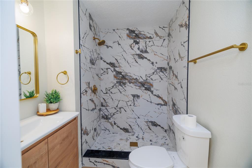 6922 Woodlake Drive, Unit 103 Orlando, FL 32810 - Photo 9 of 16 a bathroom with a toilet and a shower curtain