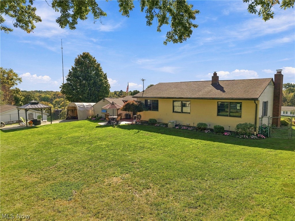 1211 Etter Road Mogadore, OH 44260 - Photo 42 of 48 Expansive rear yard featuring a manicured lawn, established landscaping, patio, and a covered gazebo
