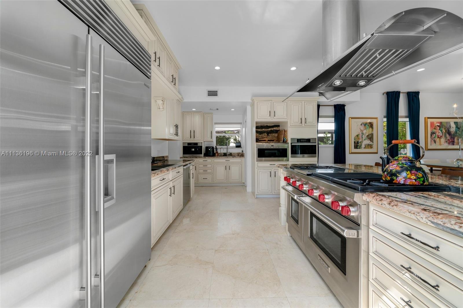 5852 Pine Tree Drive Miami Beach, FL 33140 - Photo 11 of 53 a kitchen with stainless steel appliances a stove a sink and a refrigerator