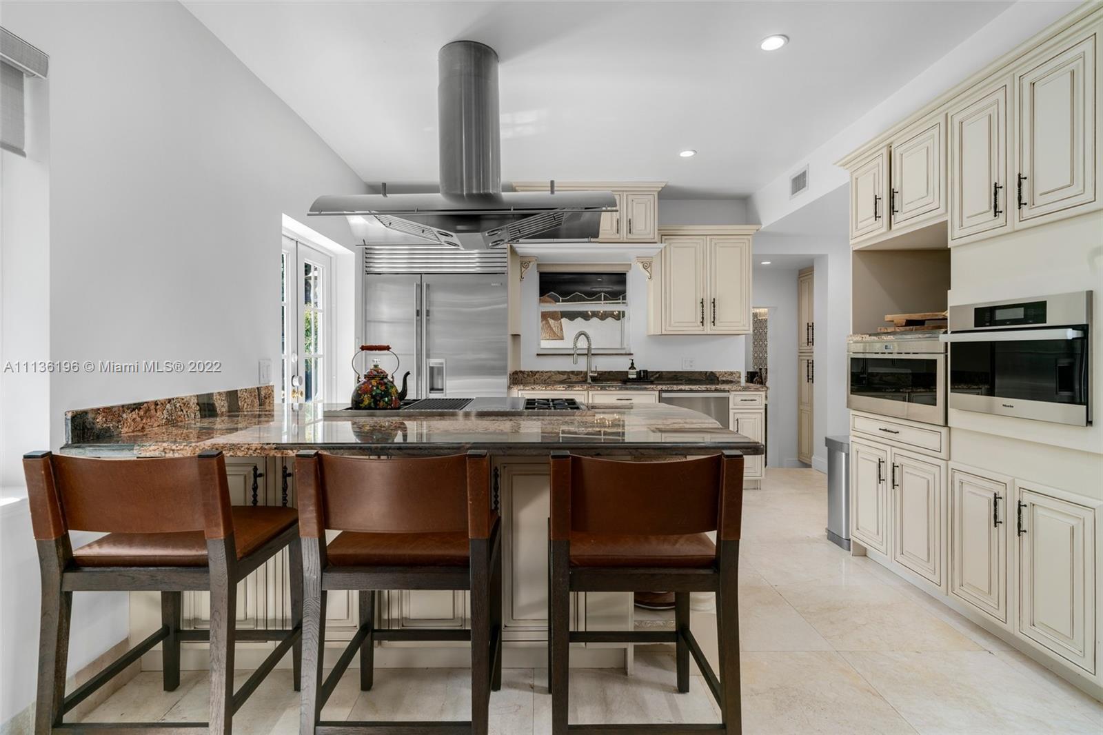 5852 Pine Tree Drive Miami Beach, FL 33140 - Photo 12 of 53 a kitchen with a table and chairs in it