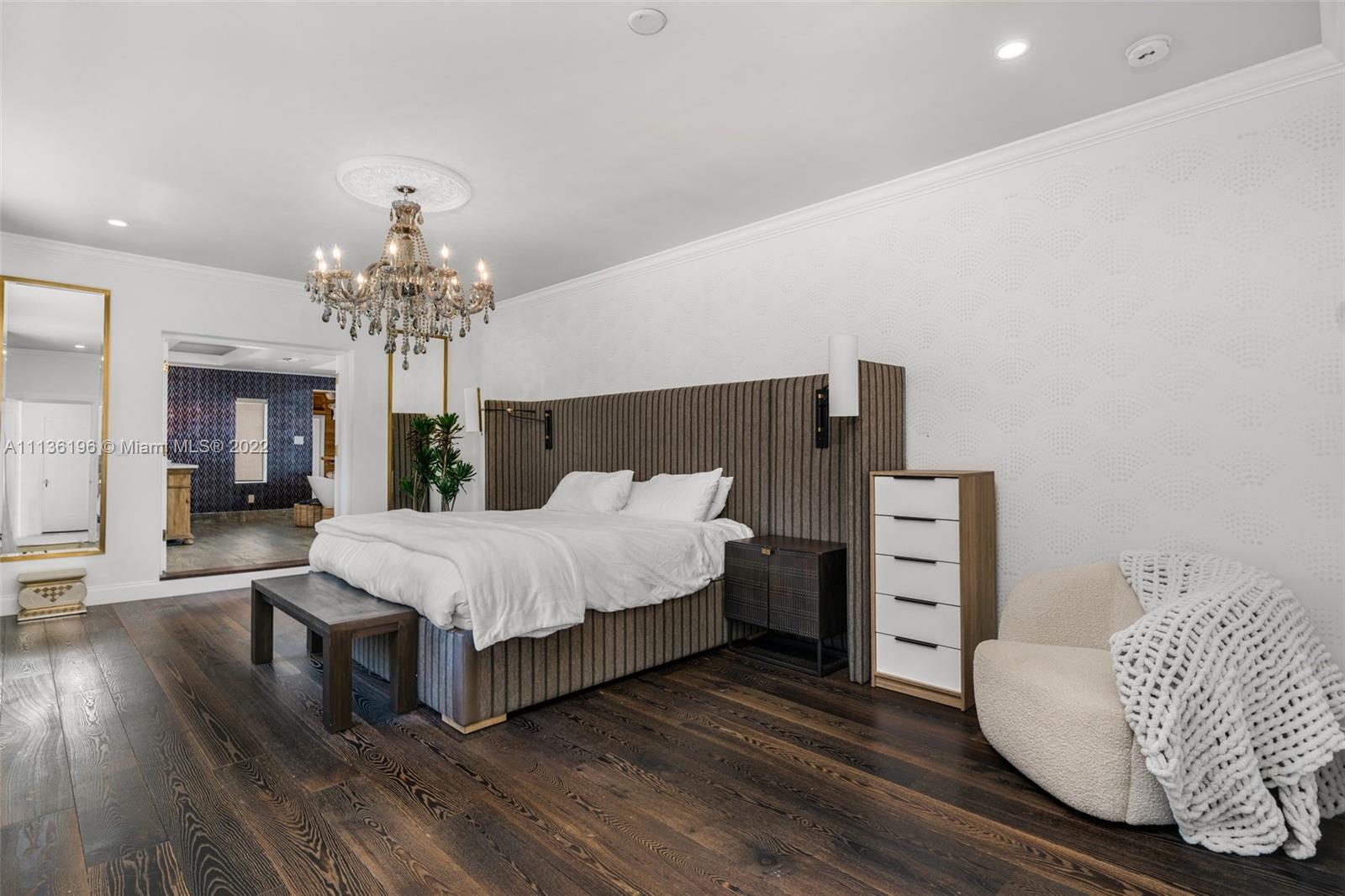 5852 Pine Tree Drive Miami Beach, FL 33140 - Photo 20 of 53 a spacious bedroom with a bed and a chandelier